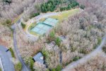 Aerial view of tennis courts and walking trail behind house